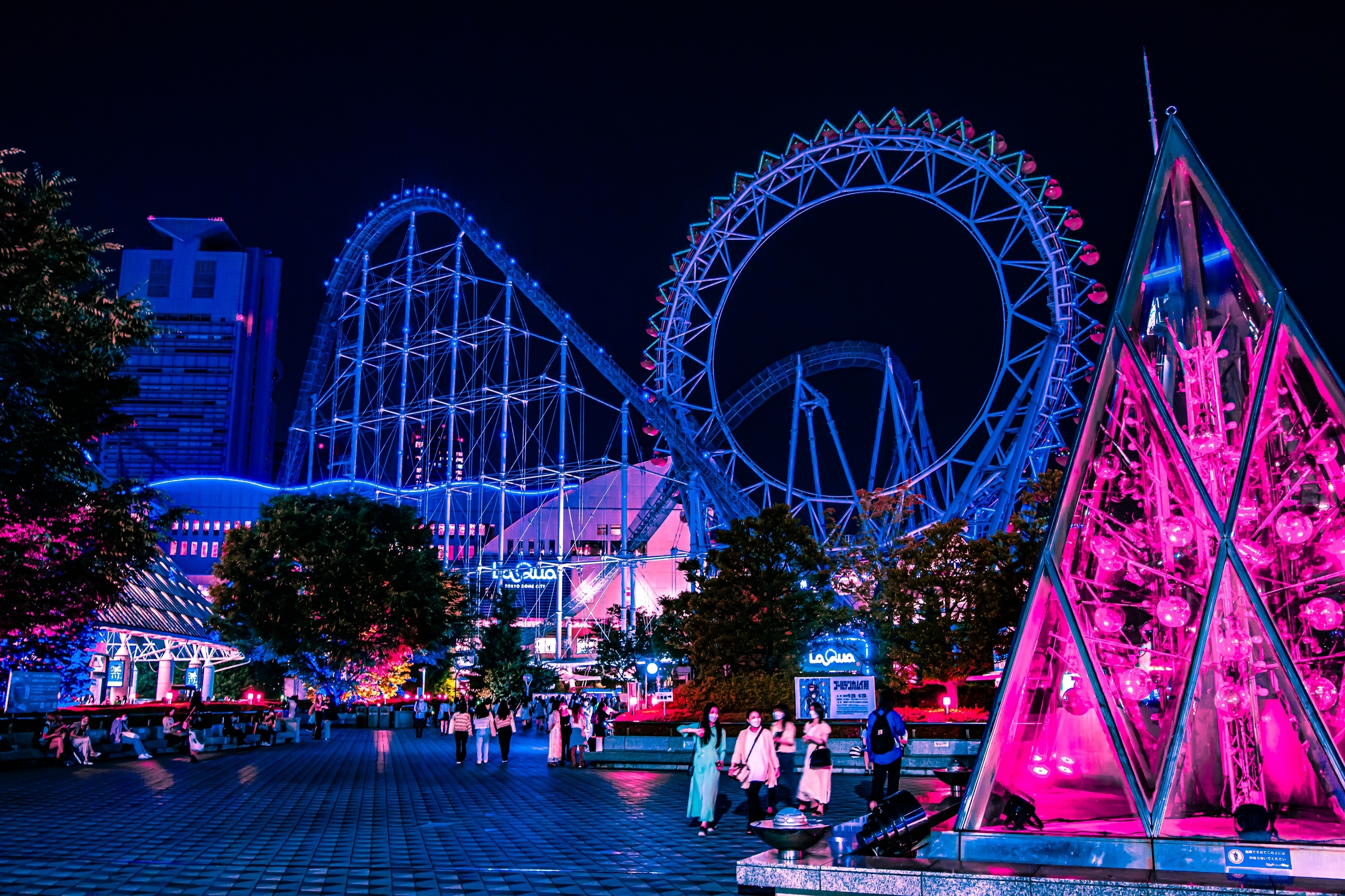 Neon-lit amusement park and Ferris wheel at night